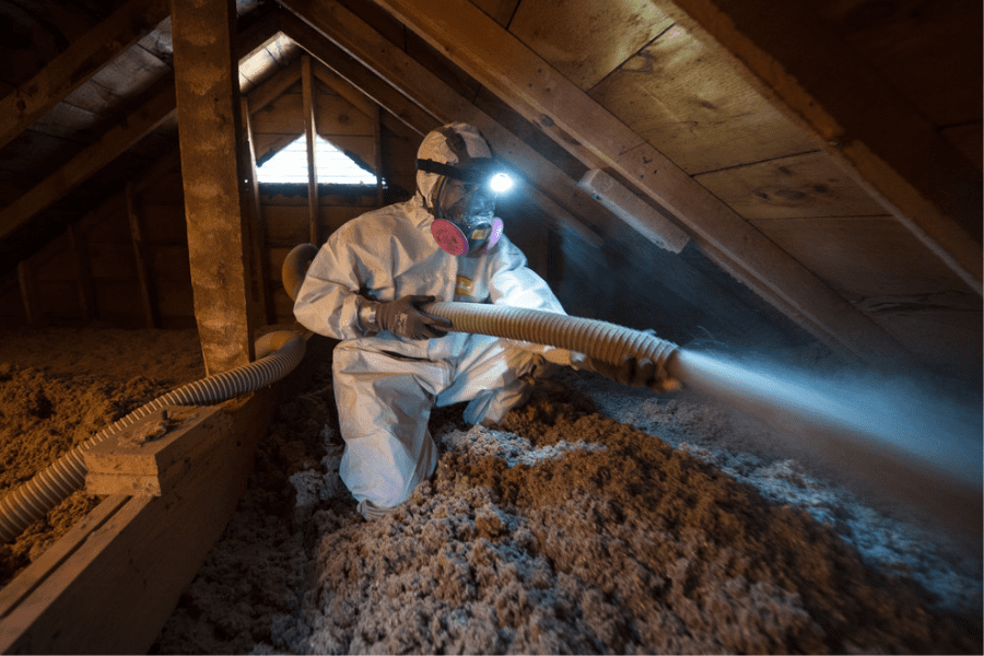 Person blowing insulation into an attic